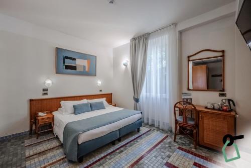a hotel room with a bed and a mirror at HOTIDAY Room Collection - Le Grazie in Portovenere