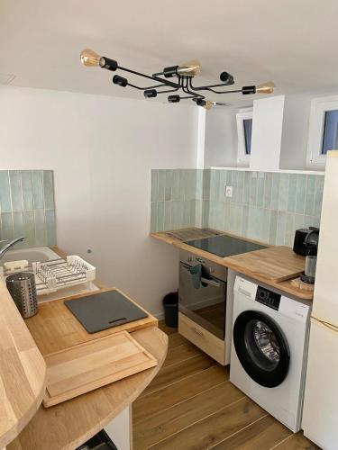 une cuisine avec une machine à laver et une table dans l'établissement House Fisherman, à Yport