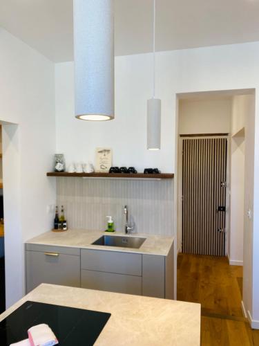 une cuisine avec un évier et un comptoir dans l'établissement 'Lazare' T3 Climatisé, Centre-ville, Wifi, à Sète