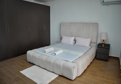 a large bed with two pillows on it in a room at Urban Rest Homes in Bamburi