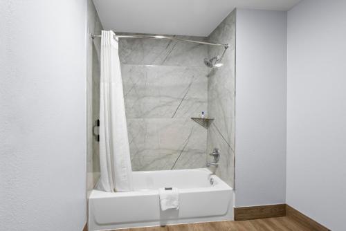 bagno con doccia e vasca bianca di Americas Best Value Inn-Gonzales a Gonzales
