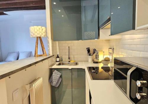 une cuisine avec un évier et un plan de travail dans l'établissement Chez Maëlle - Tour Eiffel Cosy Flat, à Paris