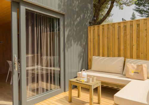 a patio with a couch on a wooden deck at CAMPING SÈNIA RUPIT in Rupit