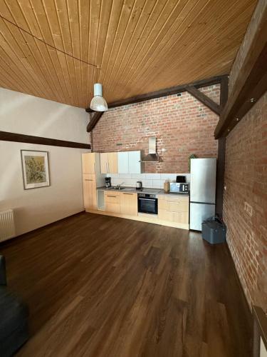 a large room with a brick wall and a kitchen at SAV Ferienwohnung in Erfurt