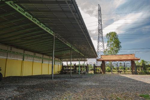 a large building with a yellow wall and a pavilion at Queen Island Kampot in Kampot