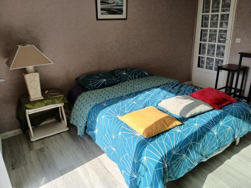 une chambre avec un lit avec des oreillers dessus dans l'établissement Paisible studio tout confort en bords de Seine, à Juziers