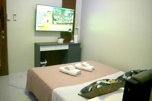 a hotel room with two beds and a flat screen tv at Meta Rose Mactan Residences in Buaya
