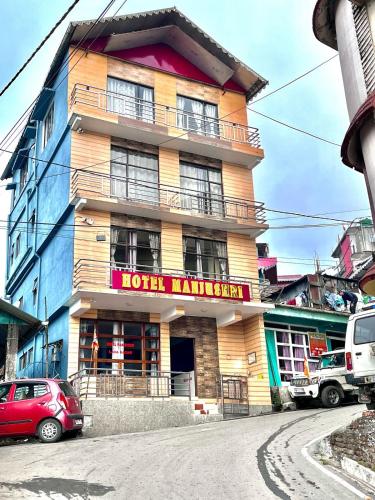 a hotel building with a red car parked in front of it at Hotel Manjushree in Lava
