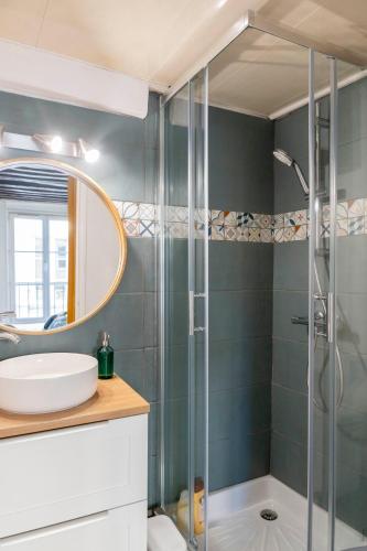 une salle de bain avec une douche avec un lavabo et un miroir dans l'établissement Charming studio - Rue Froide, à Caen