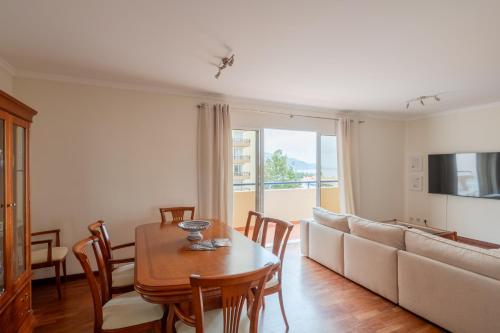 a living room with a table and a couch at Madeira Sunny Penthouse in Funchal