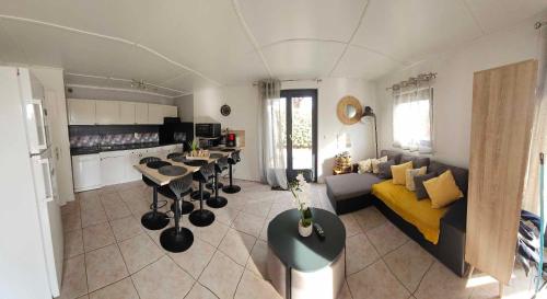 un grand salon avec un canapé et une cuisine dans l'établissement Maison tout confort 4 ch 8p domaine privé avec piscines, et plage à 10 min à pied, à Portiragnes