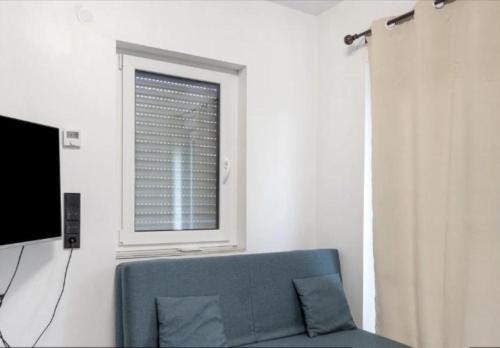 a living room with a blue couch and a window at Biberschätzli in Tengen