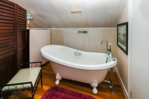 una vasca da bagno in un bagno con una panca di Sea Charm - Downtown, Screened porch! a Chincoteague