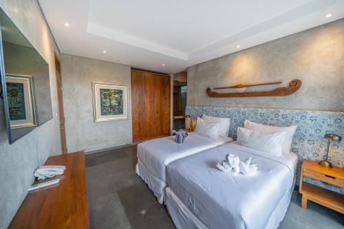 a hotel room with two beds and a table at Ubud Diary Villa in Ubud