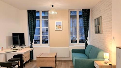 - un salon avec un canapé, une table et 2 fenêtres dans l'établissement Le Nid'Vernais, à Nevers