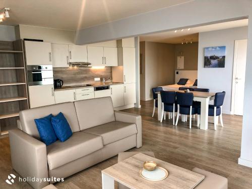 a living room and kitchen with a couch and a table at Holiday Suites Blankenberge in Blankenberge