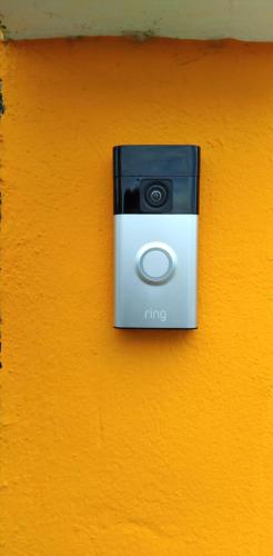 a black and white camera on a orange wall at NO CASH ACCEPTED-MEETING POINT-Volcanic Beach Refuge-Group Housing in São Filipe