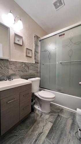 a bathroom with a toilet and a sink and a shower at Ohana Wynwood in Miami
