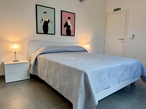 a bedroom with a bed with two pictures on the wall at Stylish Boutique Duplex Apartment Home - Orange - 2 Double Bedrooms in Hamrun