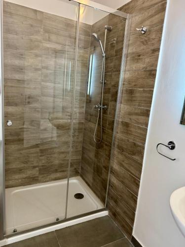 a shower with a glass door in a bathroom at Stylish Boutique Duplex Apartment Home - Orange - 2 Double Bedrooms in Hamrun