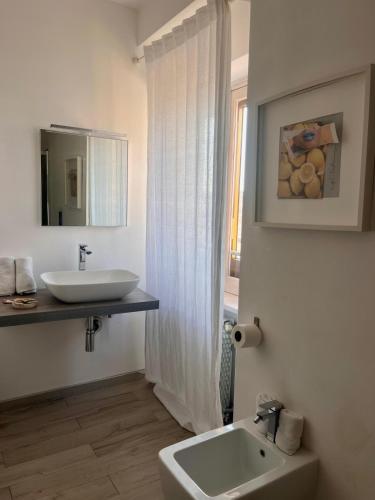 a white bathroom with a sink and a mirror at piazza Marconi Rooms in Manfredonia