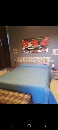 a bedroom with a bed with a blue comforter at Affittacamere Erbagatta in Erba