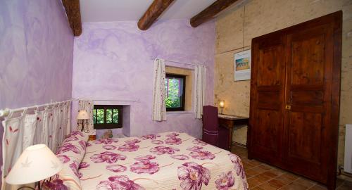 a bedroom with a bed and purple walls at Maison d'Hôtes Lou Geneste in Bollène