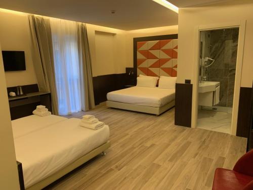 a hotel room with two beds and a bathroom at JR Hotels Bocconi Milano in Milan