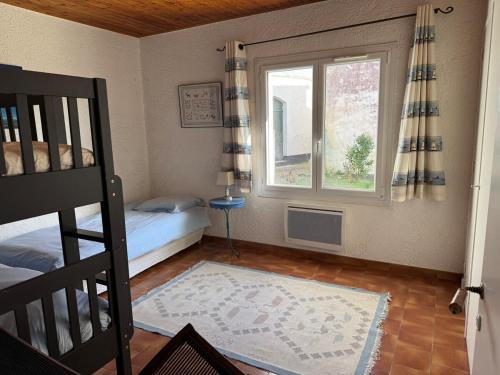 une chambre avec un lit superposé et une fenêtre dans l'établissement ღ Maison des Dunes - 3 chambres, Jardin & Proche Plage, à Saint-Clément-des-Baleines