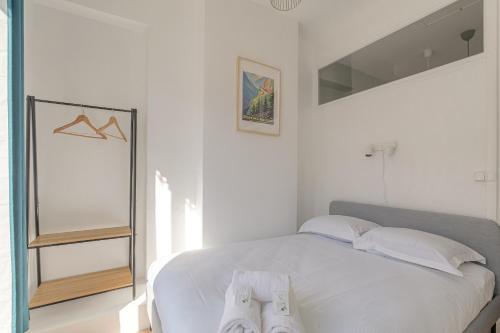 une chambre blanche avec un lit et un miroir dans l'établissement Charmant et Cosy idéal déplacement pro, à Villeurbanne