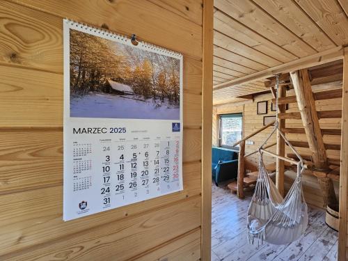 a calendar on the wall of a cabin with hammocks at Młynówka Domek przy Młynie in Krościenko