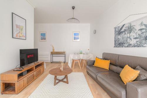 un salon avec un canapé et une télévision dans l'établissement Charmant et Cosy idéal déplacement pro, à Villeurbanne