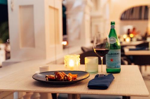 a table with a plate of food and a glass of wine at Rosedon - Adults Only from Jan 2025 in Hamilton