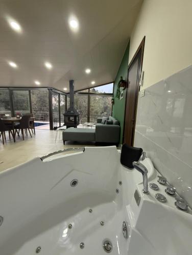 a bathroom with a bath tub and a living room at Amaruna LB in Al Qarşā