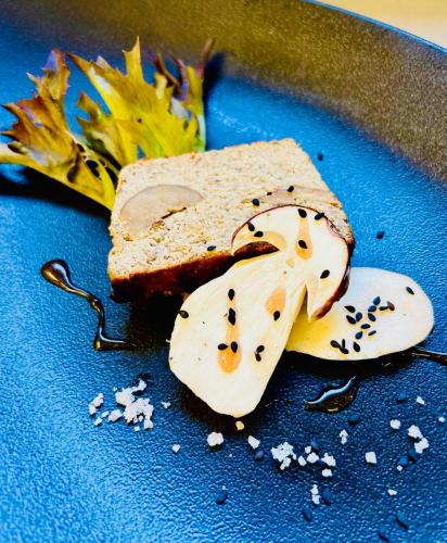 a blue plate with a piece of bread and a sandwich at Hotel La Sapinière in Brioude