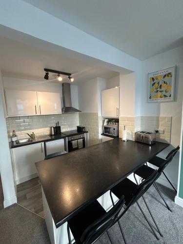 a kitchen with a large black table and chairs at Town Centre Apartments by the Beach, BIC, Pavilion in Bournemouth