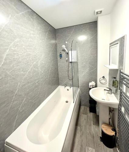 a bathroom with a bath tub and a sink at Town Centre Apartments by the Beach, BIC, Pavilion in Bournemouth