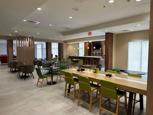 a restaurant with green chairs and tables in a room at Holiday Inn Daytona Beach LPGA in Daytona Beach