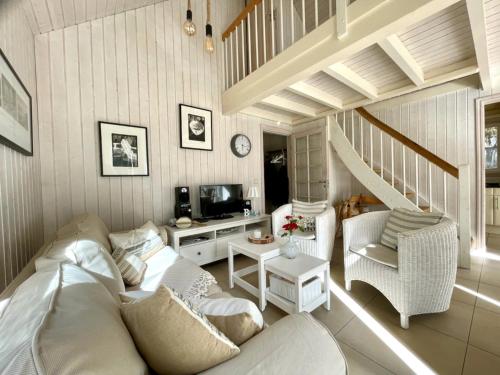 a living room with a white couch and a tv at Sandrose - Baabe in Baabe