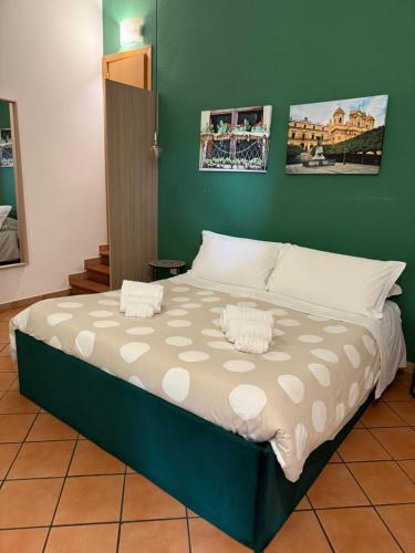 een groot bed in een kamer met een groene muur bij Bnb San Barnaba in Catania