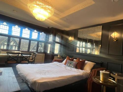 a bedroom with a large bed and a chandelier at Exquisite City Centre Apartment in Chester
