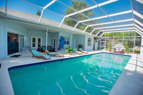 a swimming pool with chairs and a house at Huge home w pool Siesta Key and Anna Maria in Sarasota