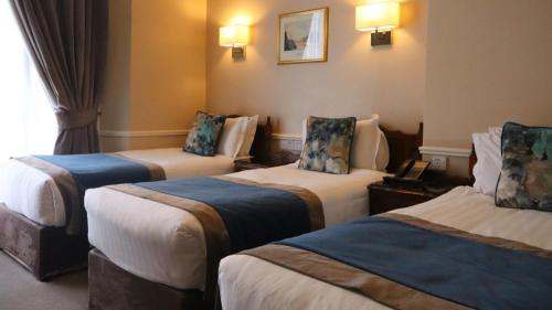 a room with three beds in a hotel room at Harrington Hall in Dublin