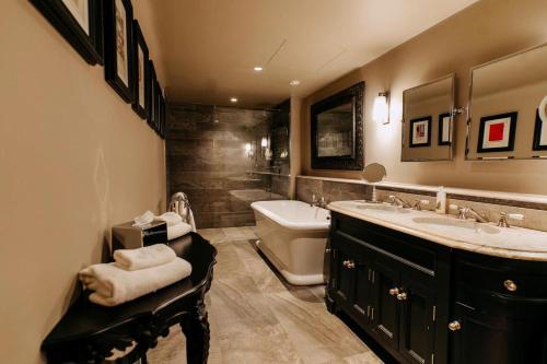 a bathroom with two sinks and a tub and a toilet at The Lion Inn in Chelmsford