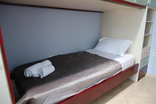 a small bed with two white towels on it at Apartment Rita Berat in Berat