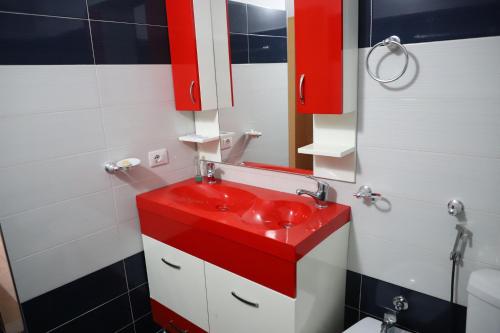 a bathroom with a red sink and a mirror at Apartment Rita Berat in Berat