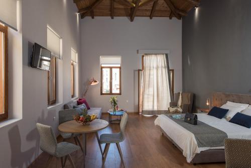 1 dormitorio con 1 cama, mesa y sillas en Bluebell Luxury Suites, en La Canea