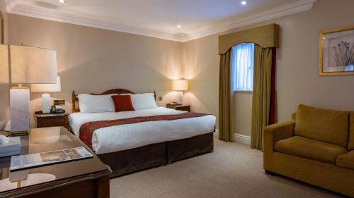 a hotel room with a bed and a chair at Harrington Hall in Dublin