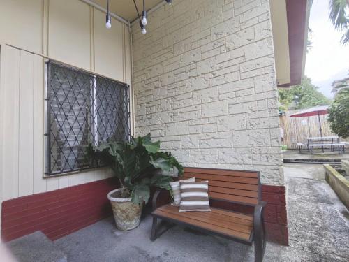 a bench sitting next to a building with a plant at Nappers Hostel in Cebu City