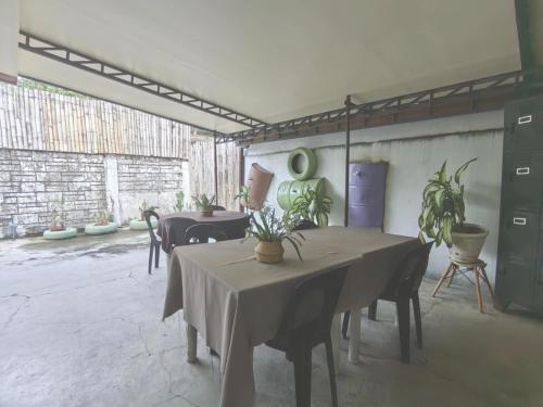 a room with tables and chairs with plants on them at Nappers Hostel in Cebu City